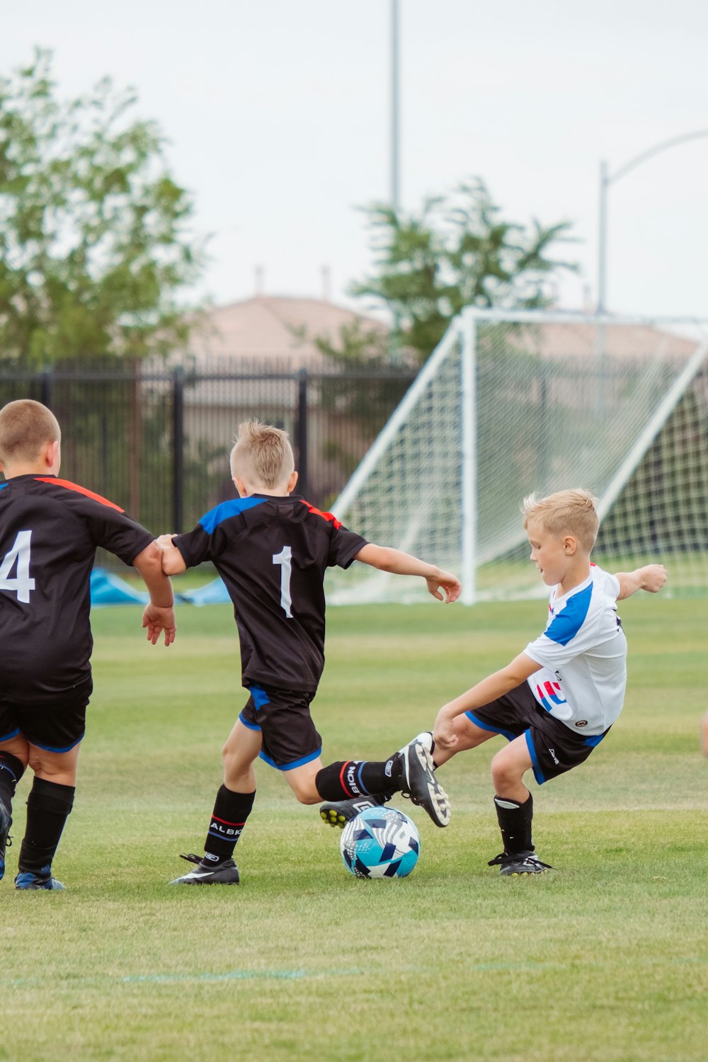 Young kids playing soccer near the goal