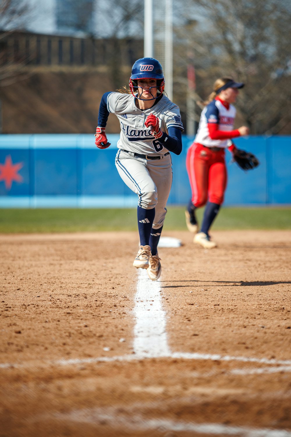 Softball player running down the first base line